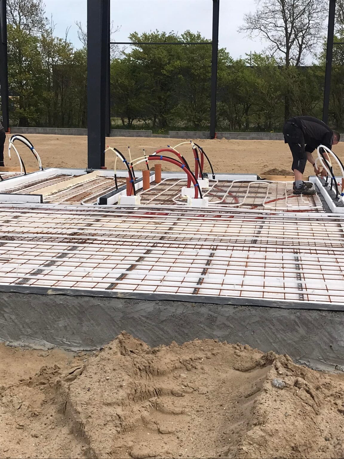 Byggeriets fundament med rørinstallation og armeringsjern