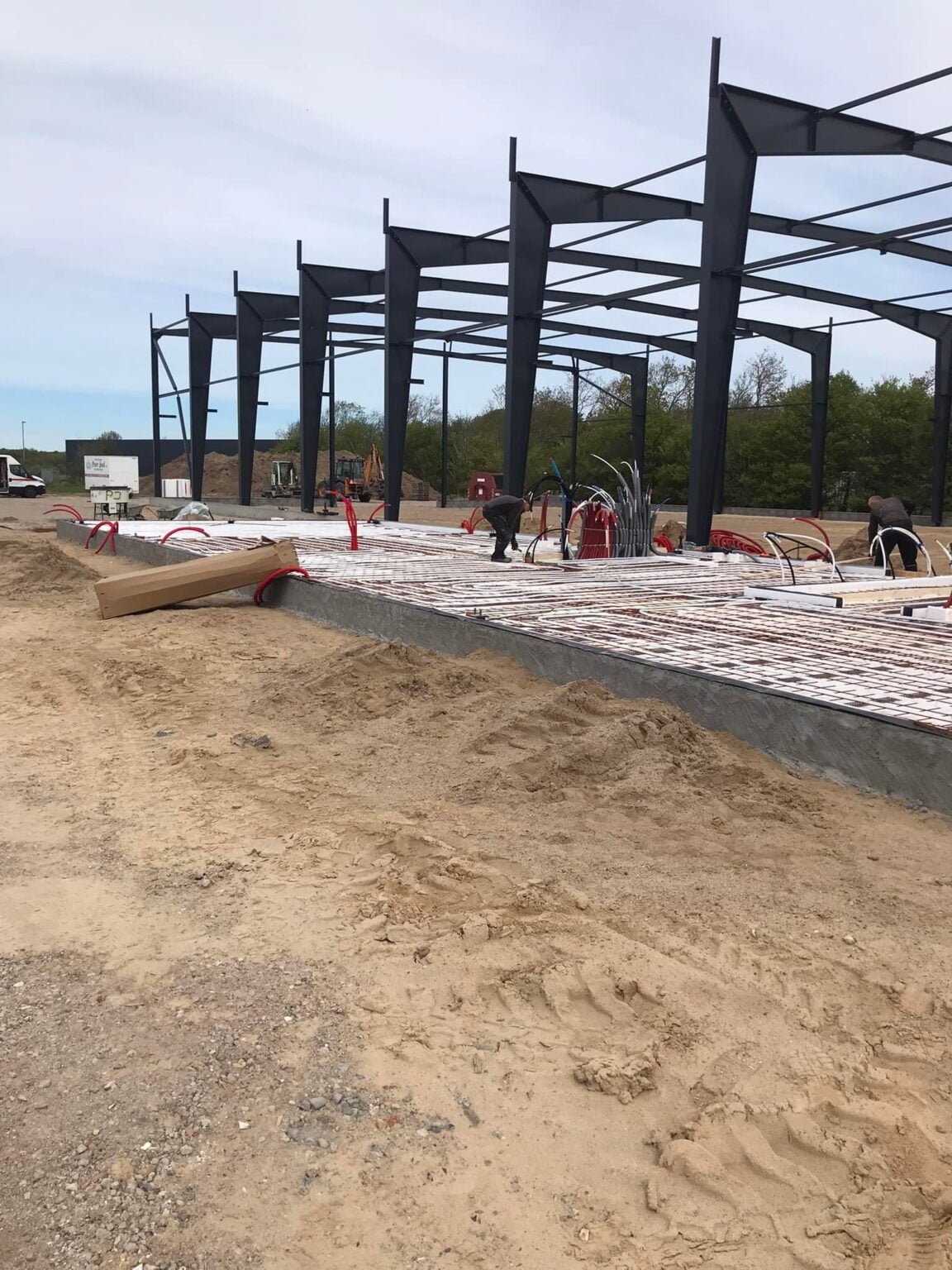 Byggeplads med stålkonstruktion og arbejdstagere