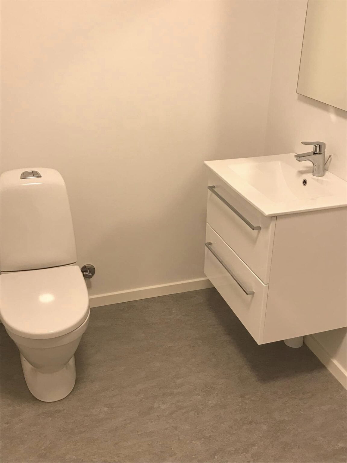 Lyst badeværelse med toilet og håndvask