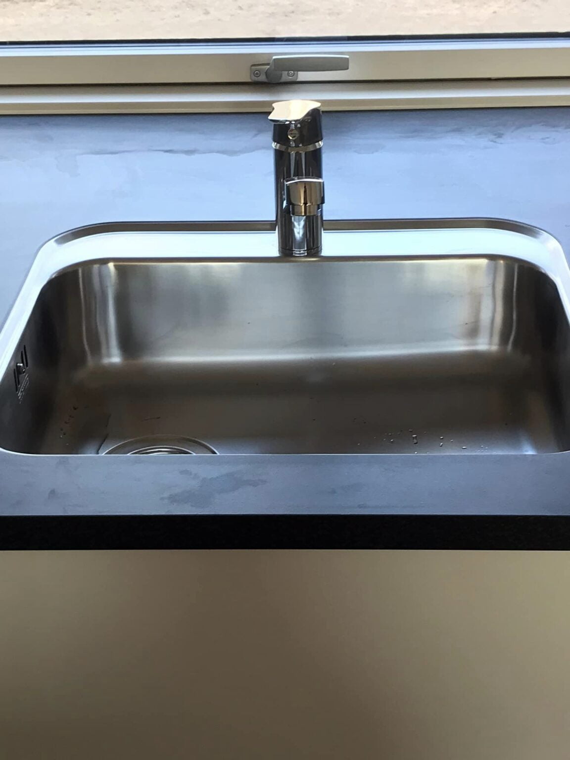 Rustfri stålvask med moderne vandhane i køkken