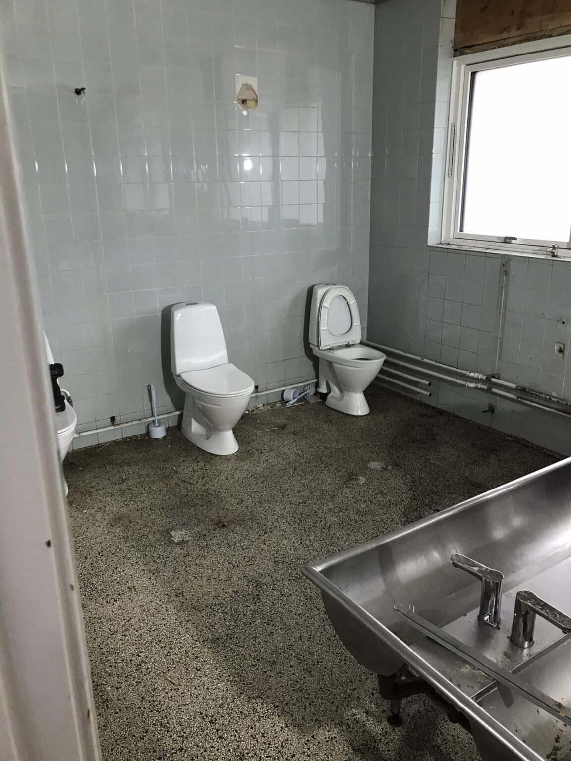 Badeværelse med tre toiletter og stålvask