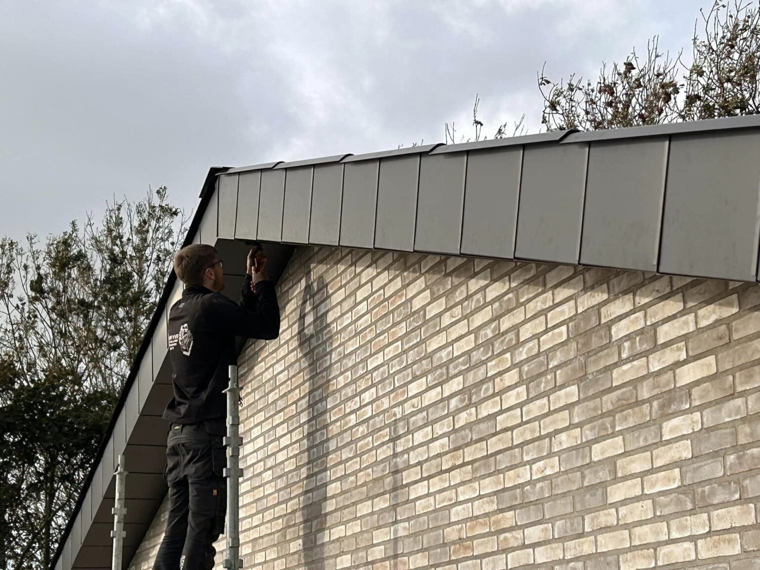 Håndværker arbejder på husets tagkant