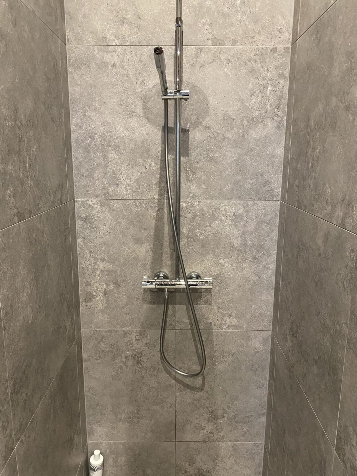 Moderne bruser i gråt flisebadeværelse