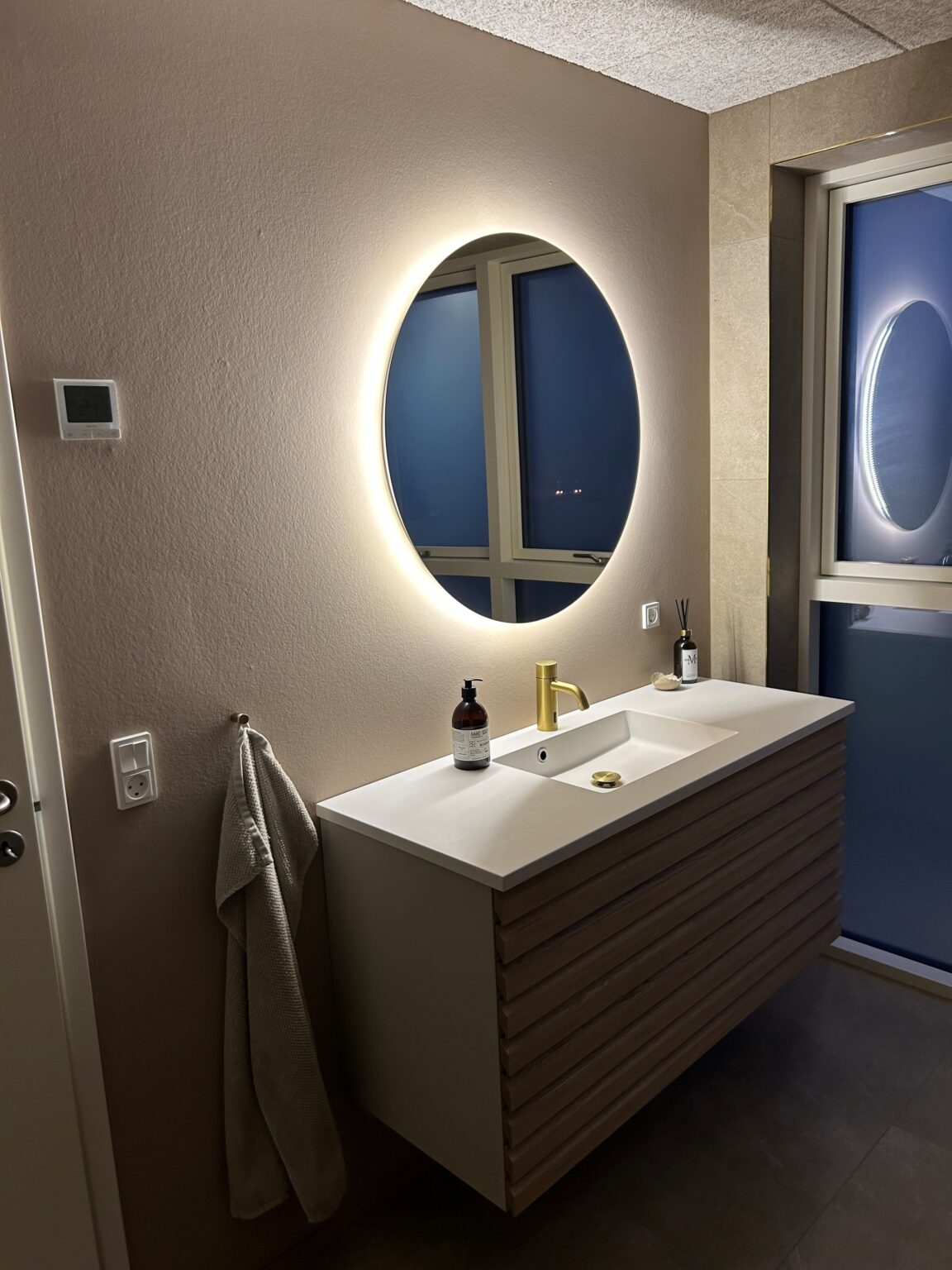 Moderne badeværelse med rundt oplyst spejl