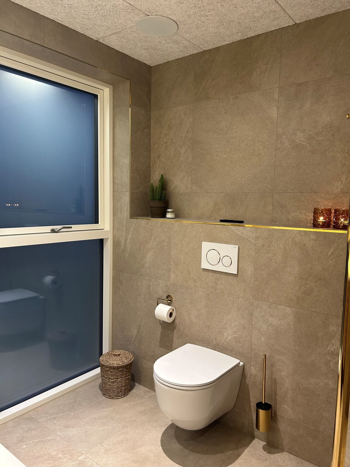 Moderne badeværelse med væghængt toilet og stor vindue