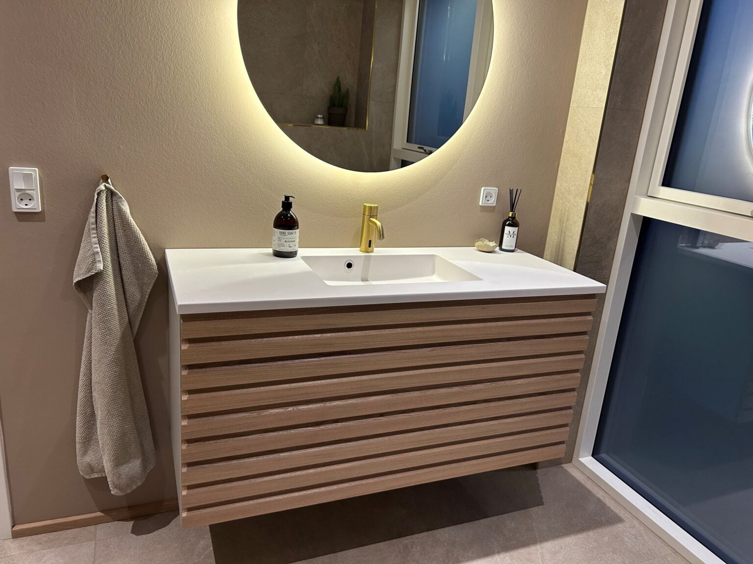 Moderne badeværelse med vask og rund spejl